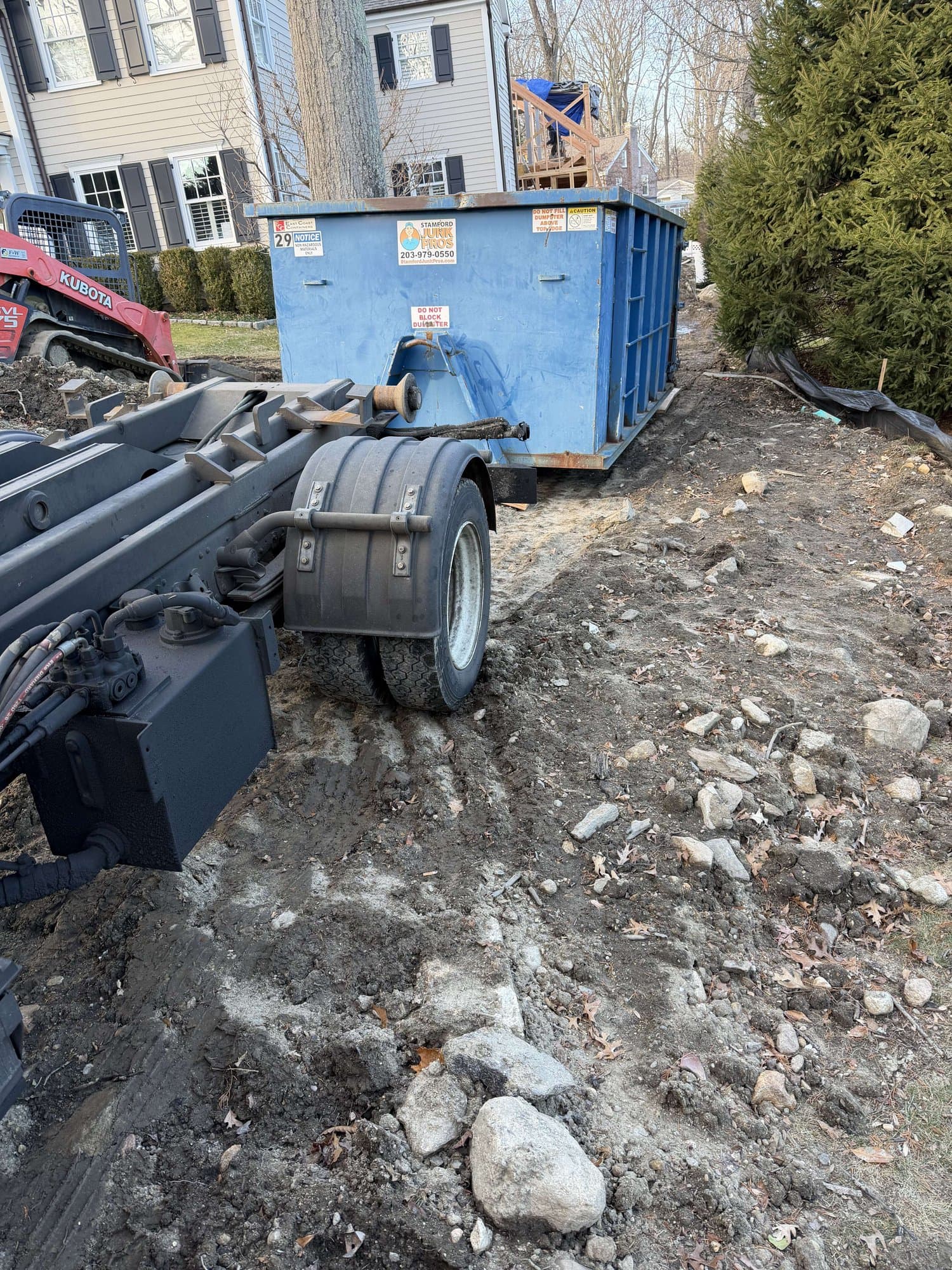 dumpster with demolition debris in New Canaan, CT by Grizzly Junk Pros