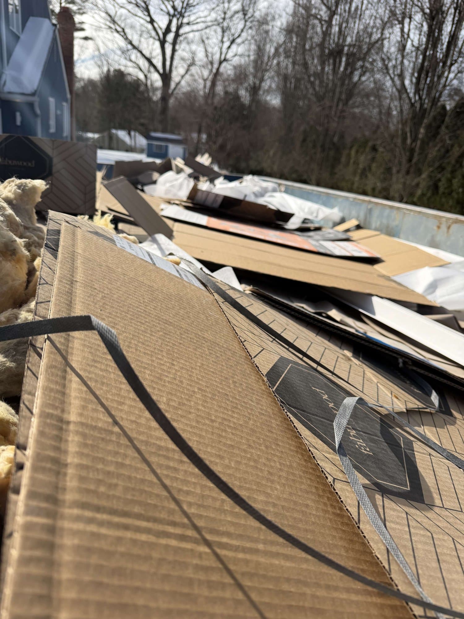 Flooring boxes and insulation from a renovation in a roll-off dumpster