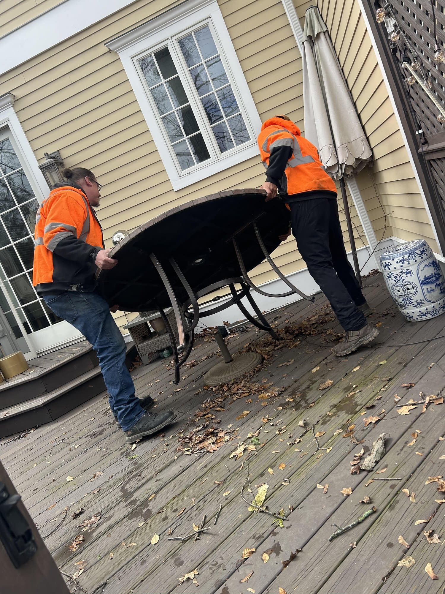 Crew carrying patio furniture off a deck