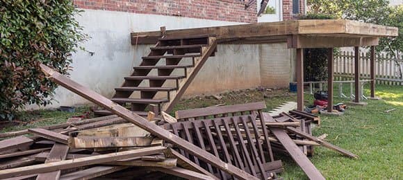 Old wooden deck and deck stairs demolished and ready for hauling by Grizzly Junk Pros