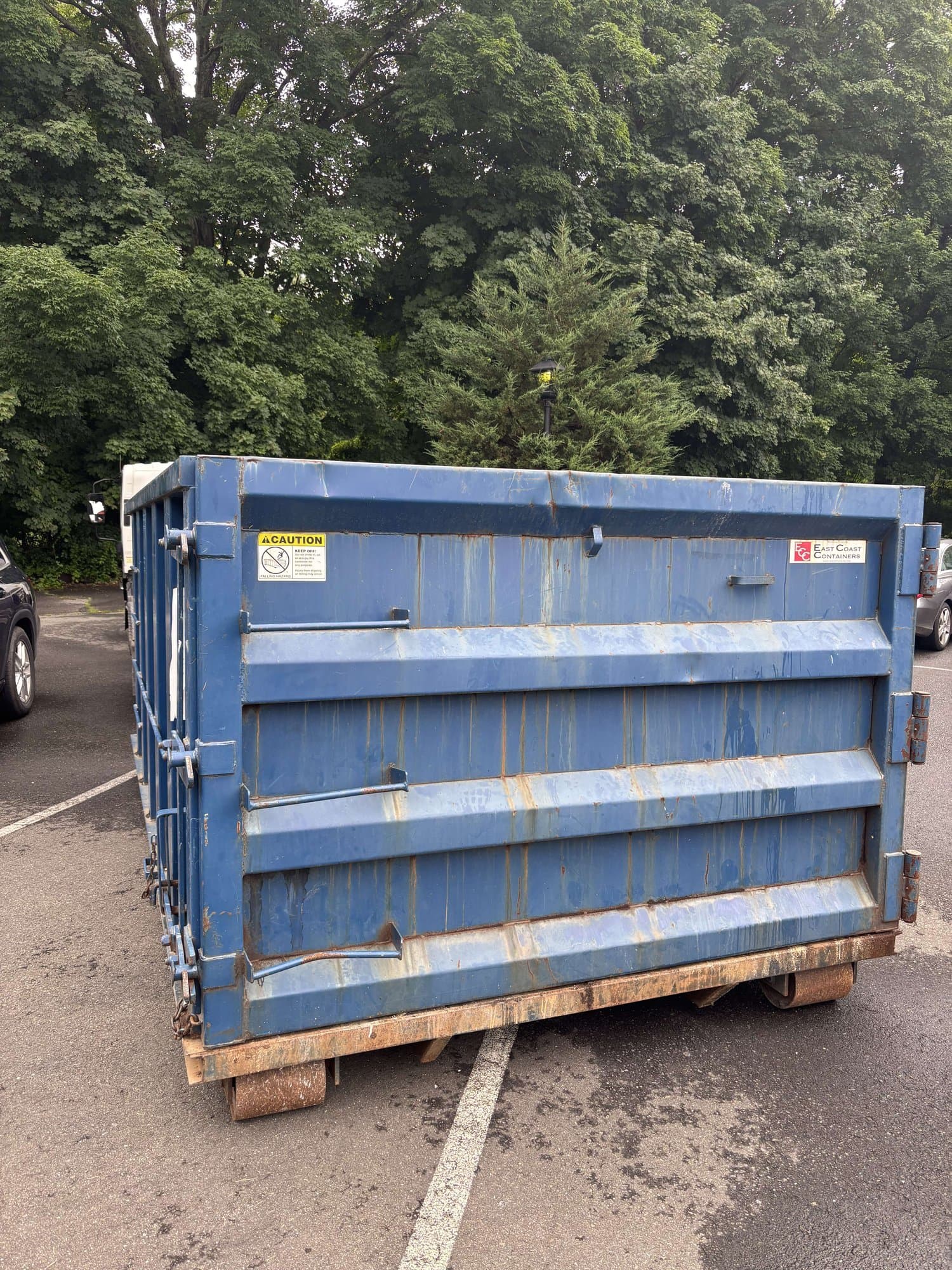 blue dumpster container by Grizzly Junk Pros