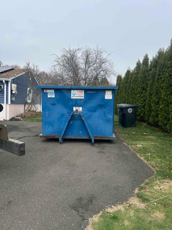 blue dumpster delivery by Grizzly Junk Pros