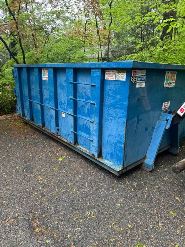 blue dumpster delivery by Grizzly Junk Pros