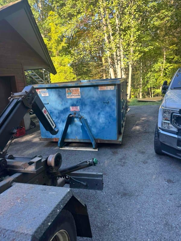 blue dumpster delivery by Grizzly Junk Pros