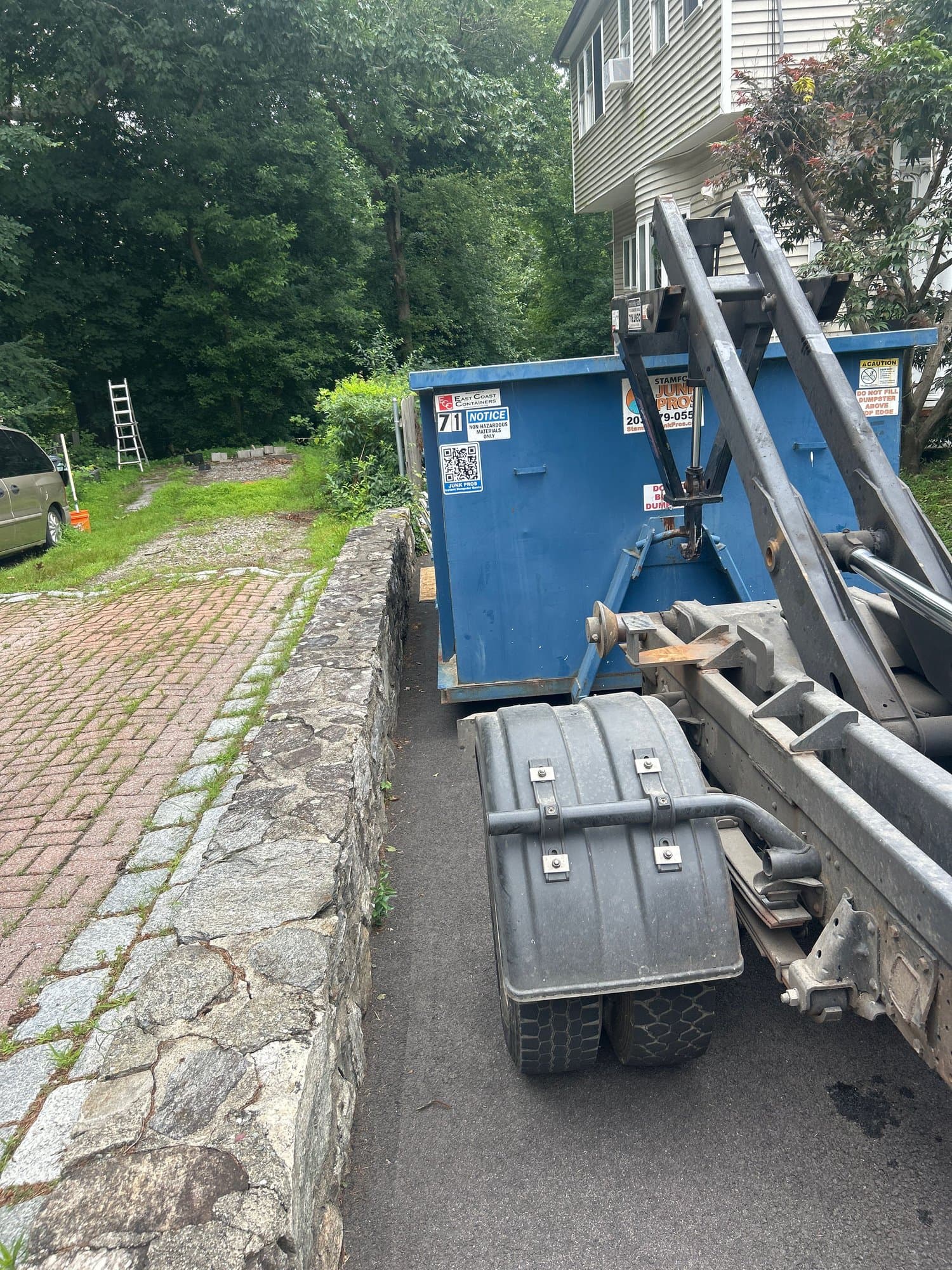 blue dumpster truck shot by Grizzly Junk Pros
