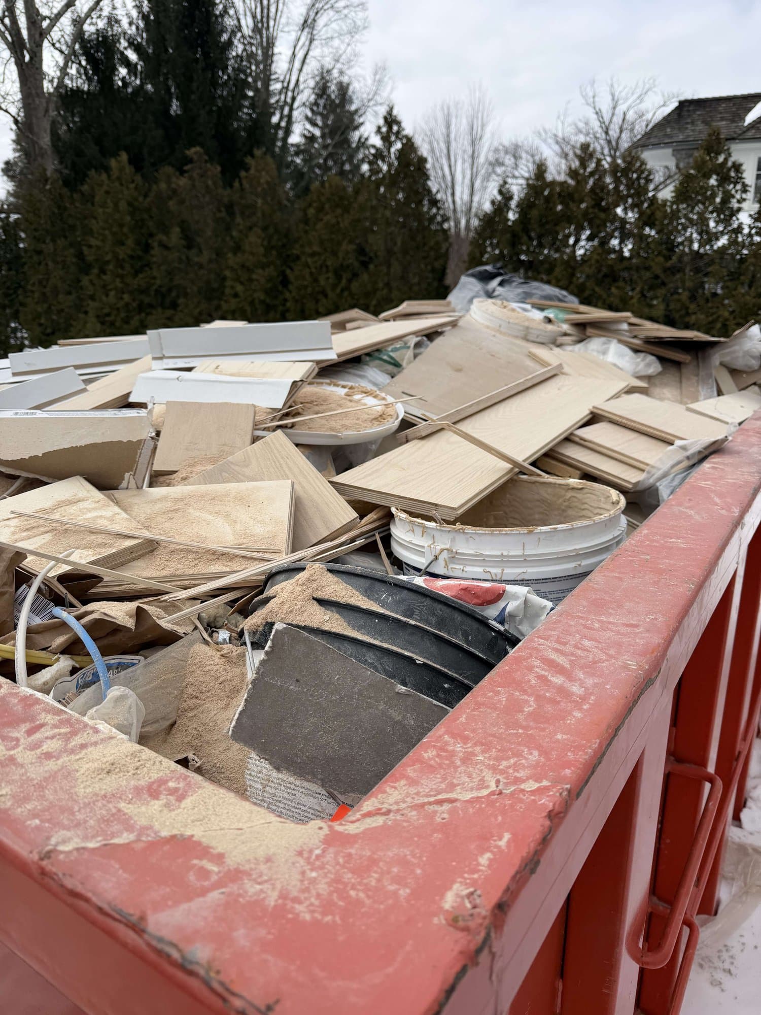 dumpster filled construction debris by Grizzly Junk Pros