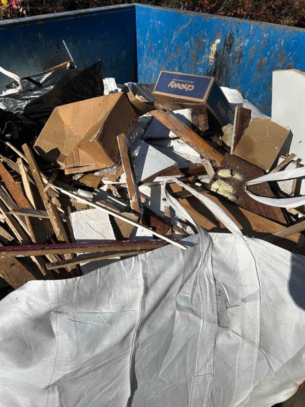 dumpster full cardboard debris by Grizzly Junk Pros