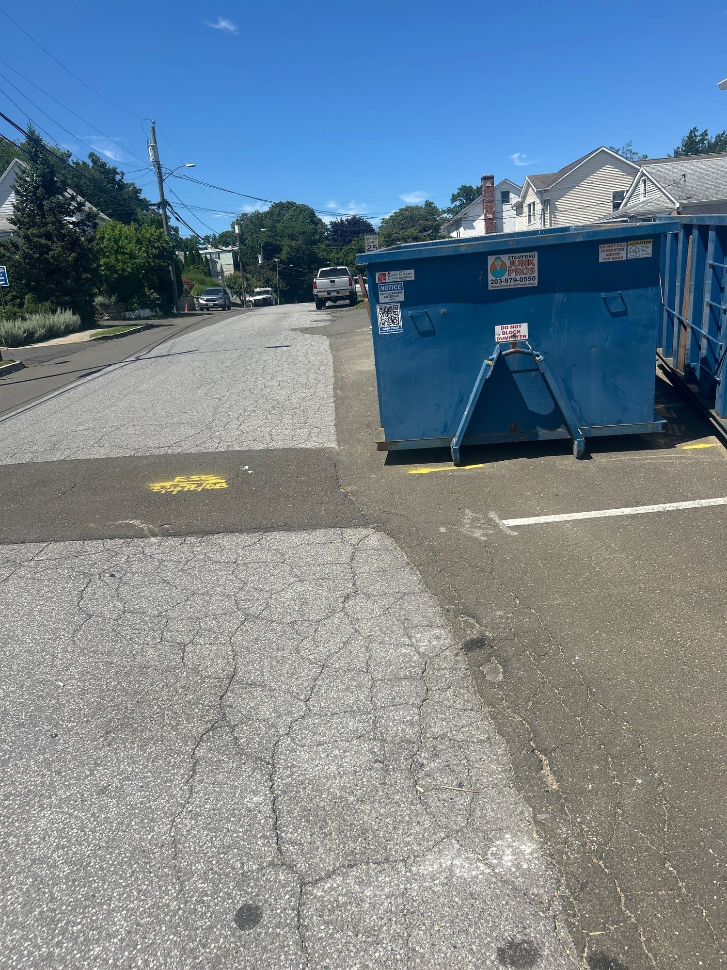 dumpster on driveway by Grizzly Junk Pros
