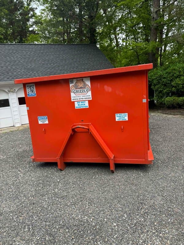 red dumpster front view by Grizzly Junk Pros